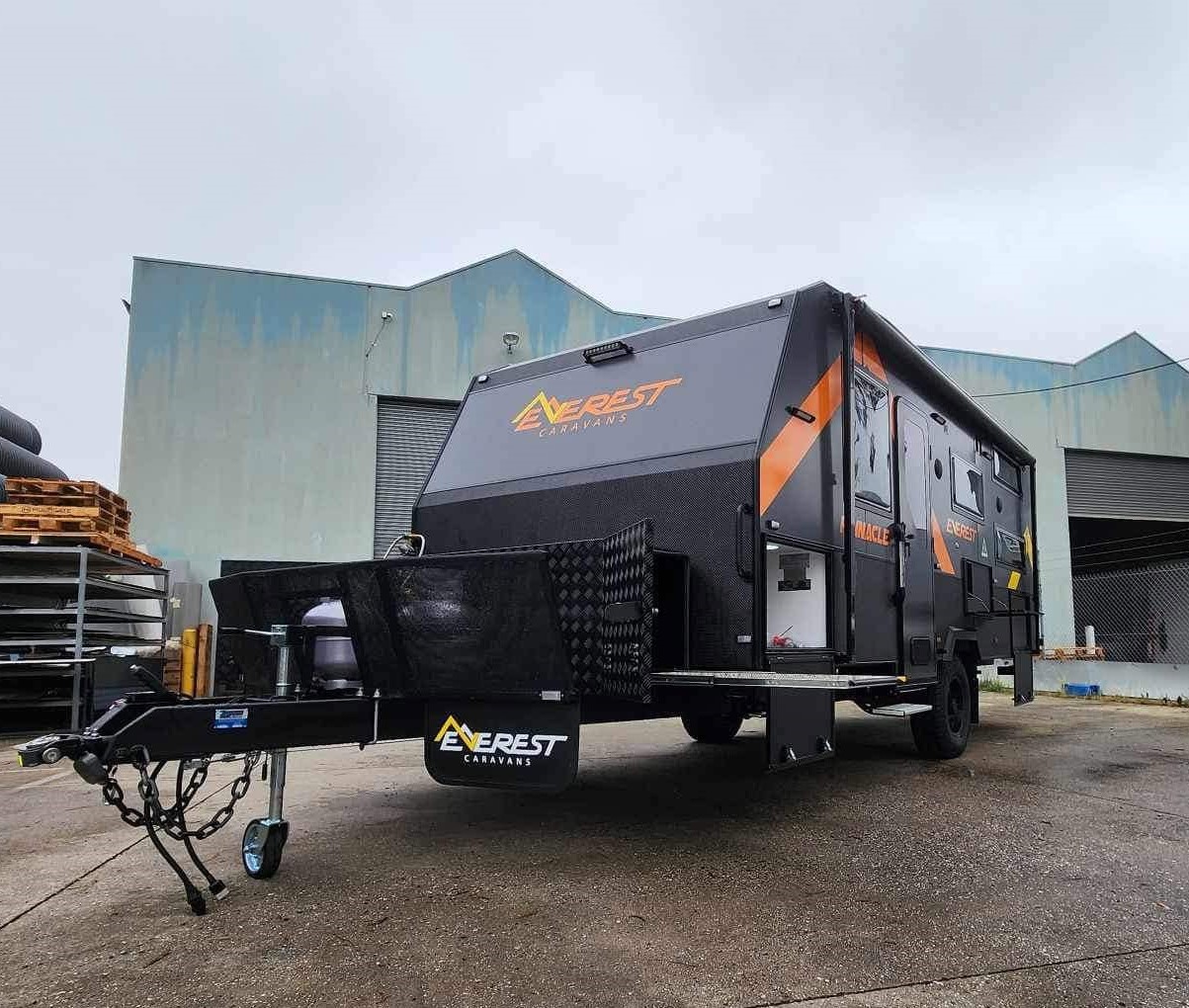 A finished Everest Pinnacle caravan outside the factory, side door open