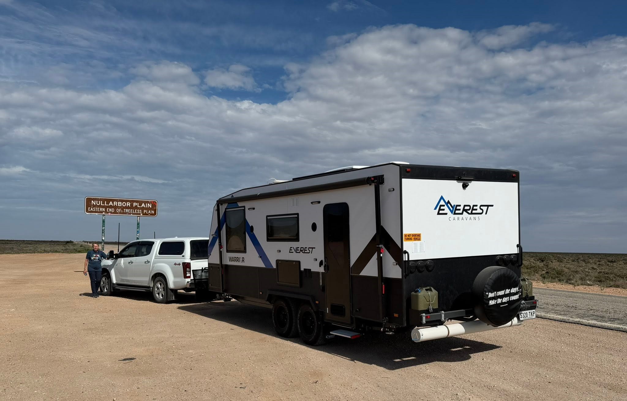 An Everest Warrior caravan and tow vehicle at the Nullarbor Plain sign