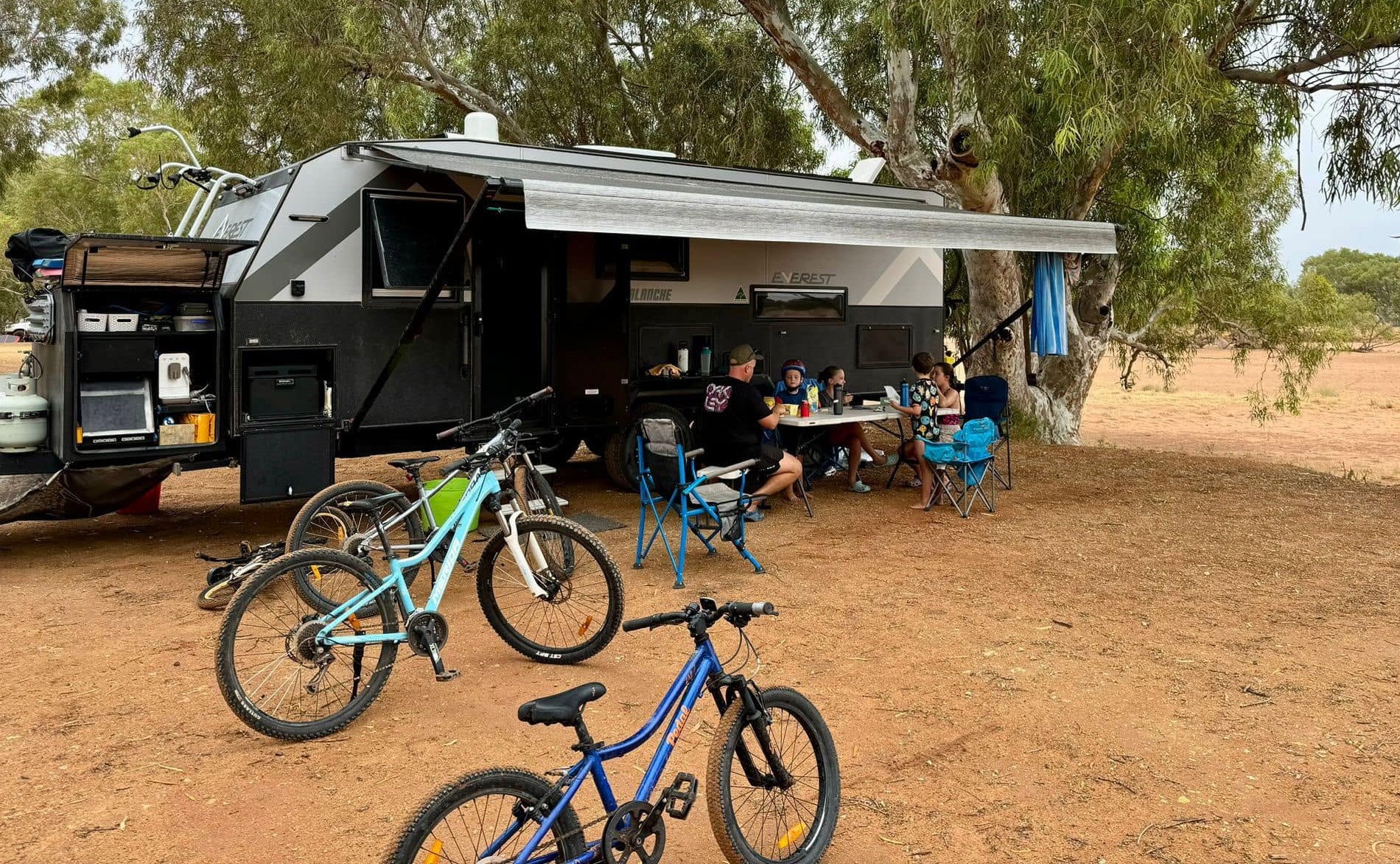 A family camped beside their Everest caravan in the outback